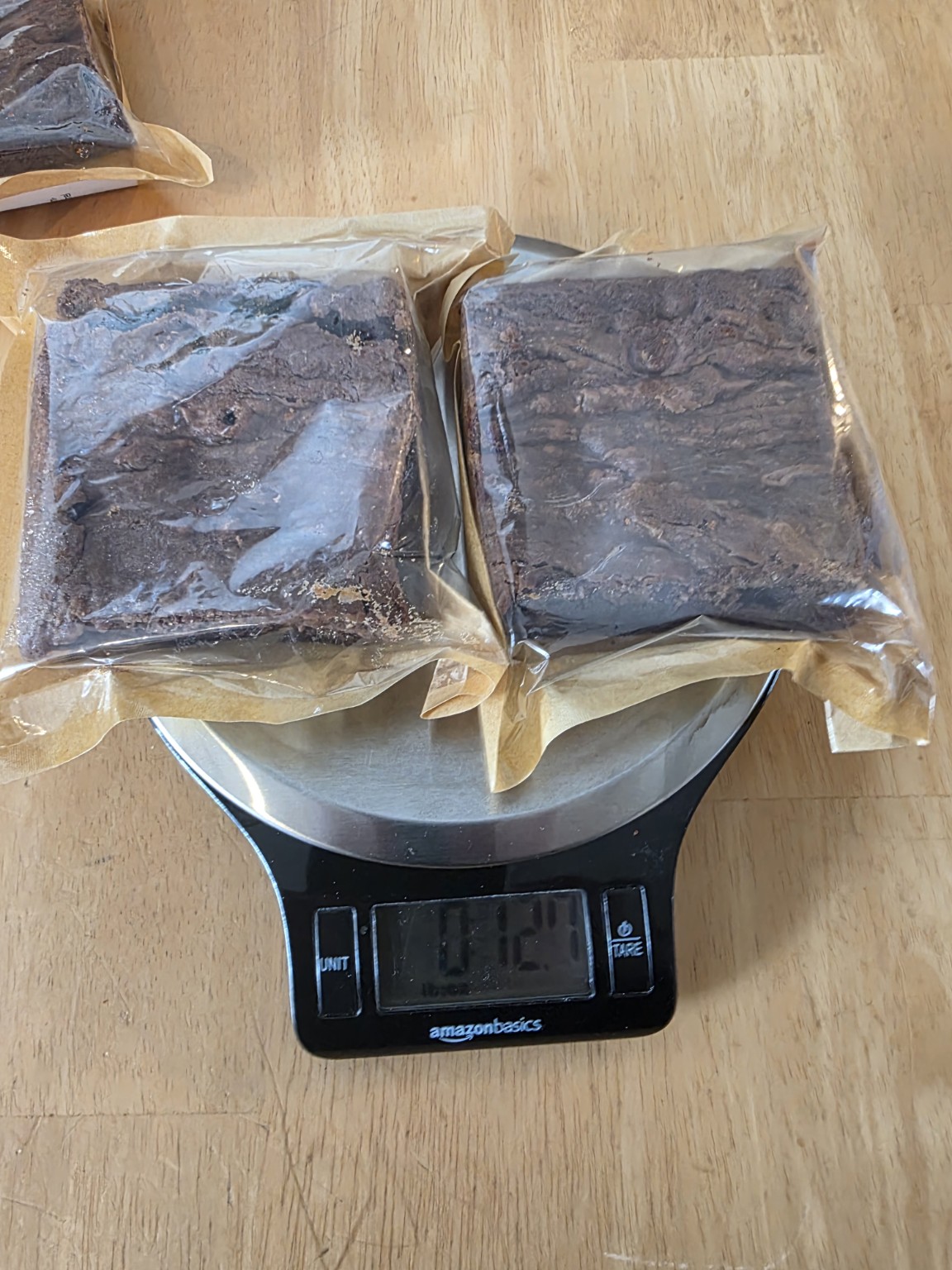 Two packaged Bad Influence Bakery Dulce de Leche brownies on a scale
