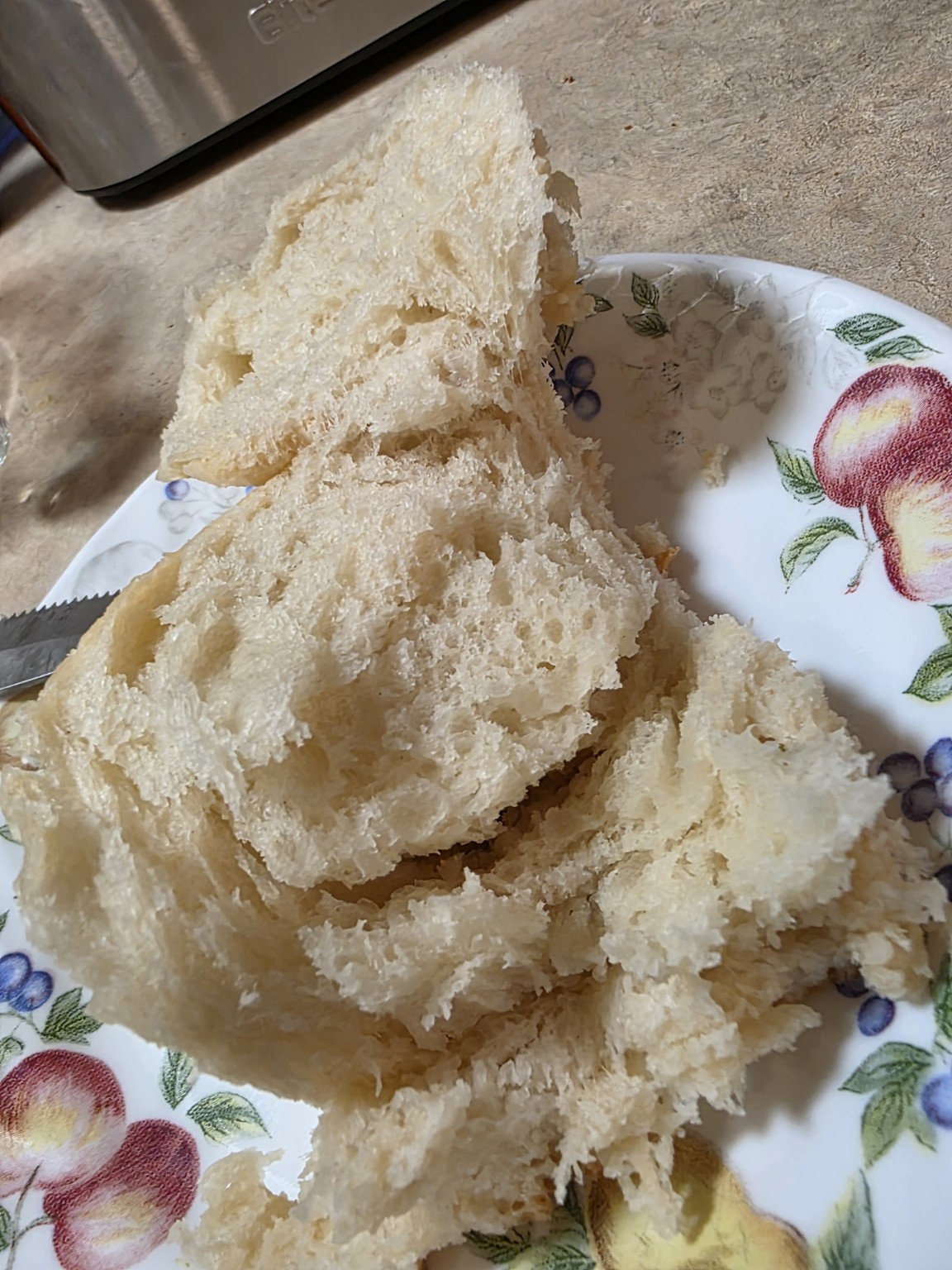 A sourdough dinner roll opened to show its soft interior